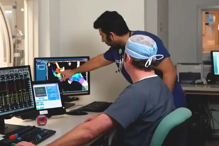 a man in a blue shirt is working on a computer