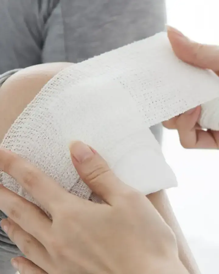 woman getting knee bandaged