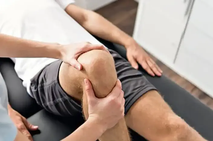 man laying on table during knee exam
