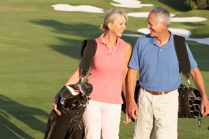 a man and woman walking on a golf course