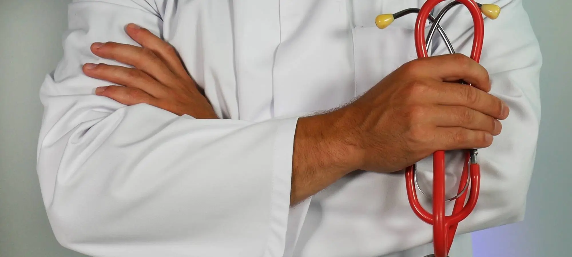 a doctor holding a stethoscope with his arms crossed