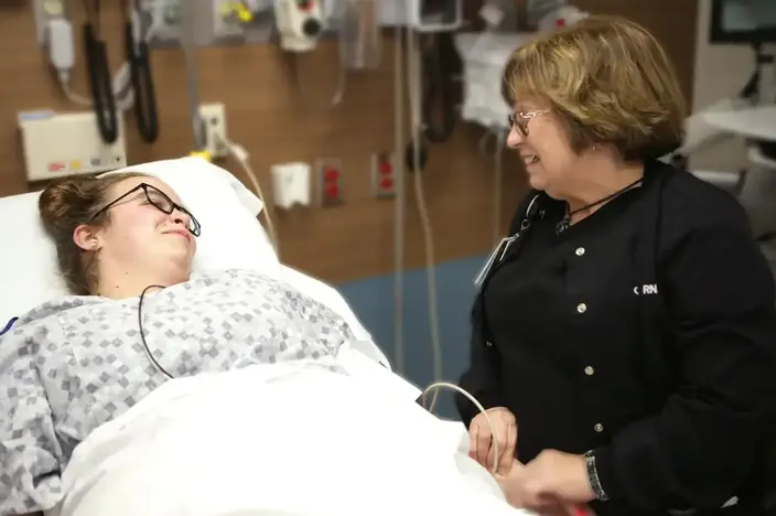 woman in hospital bed talking to nurse